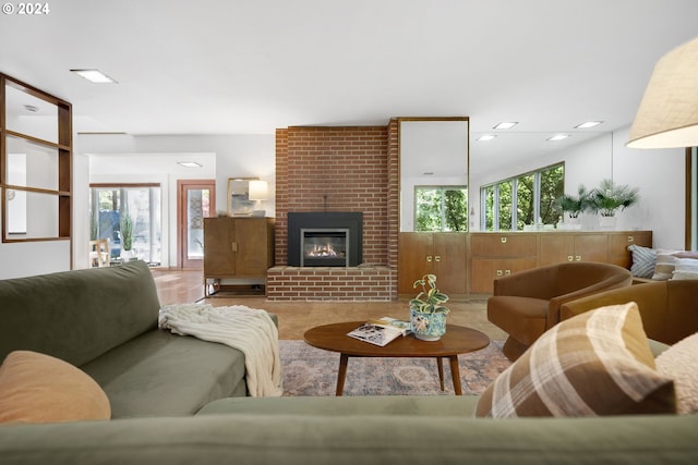 living room with a brick fireplace and hardwood / wood-style floors