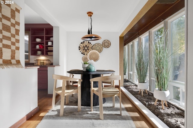 dining space with hardwood / wood-style floors and a healthy amount of sunlight