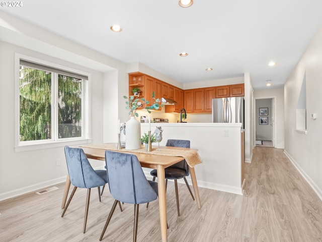 dining space with light hardwood / wood-style flooring and sink