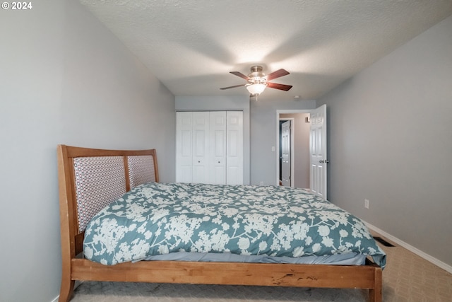 bedroom featuring carpet flooring, ceiling fan, a closet, and a textured ceiling