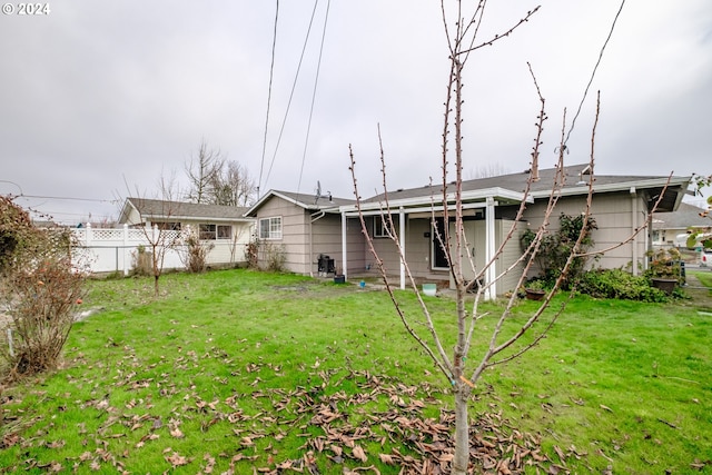 rear view of property featuring a lawn