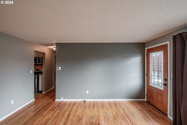 interior space featuring a textured ceiling and light hardwood / wood-style flooring