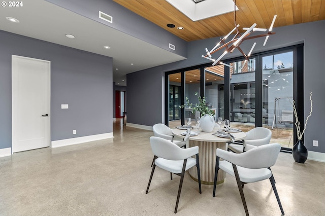 dining space featuring a skylight, a chandelier, and wood ceiling