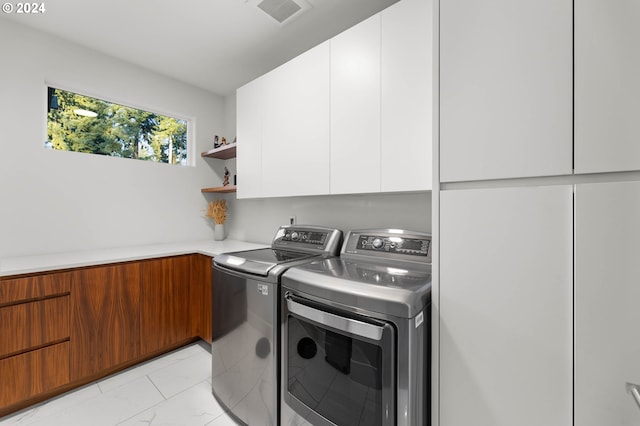 laundry room featuring cabinets and washing machine and clothes dryer