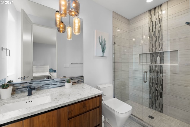 bathroom featuring a chandelier, toilet, decorative backsplash, vanity, and a shower with shower door