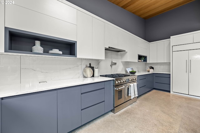 kitchen with decorative backsplash, white cabinetry, and range with two ovens