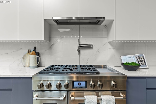 kitchen with ventilation hood, white cabinetry, light stone countertops, and high end stove