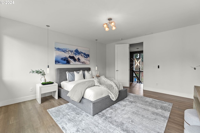 bedroom featuring a notable chandelier and wood-type flooring