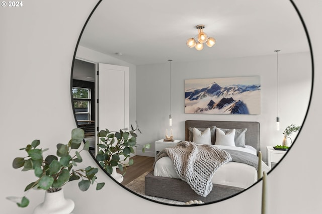 bedroom with a chandelier and wood-type flooring