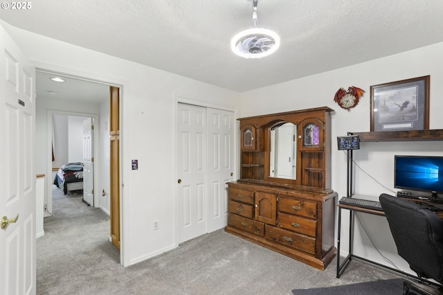 office space featuring light colored carpet and a textured ceiling