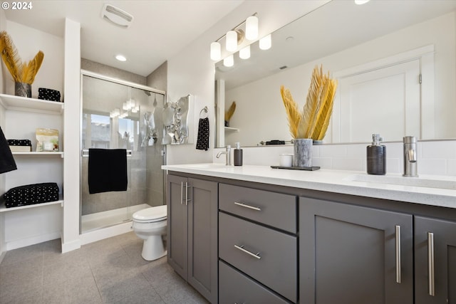 bathroom featuring tile patterned flooring, toilet, vanity, and walk in shower