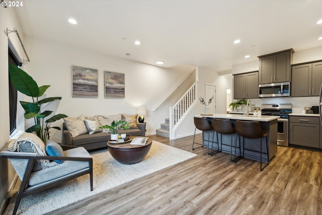 living room with hardwood / wood-style floors and sink