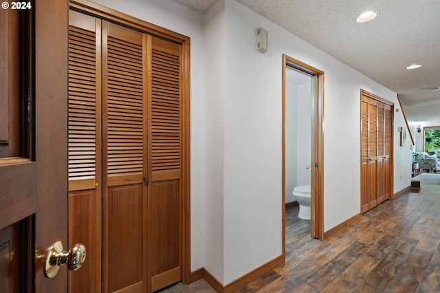 bedroom with wood finished floors, a textured ceiling, and a barn door