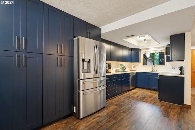 kitchen featuring sink, appliances with stainless steel finishes, a raised ceiling, and dark hardwood / wood-style flooring