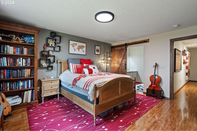 bedroom with a textured ceiling, dark hardwood / wood-style flooring, and a closet