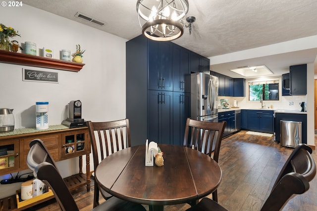 kitchen featuring light countertops, decorative backsplash, appliances with stainless steel finishes, a sink, and blue cabinets