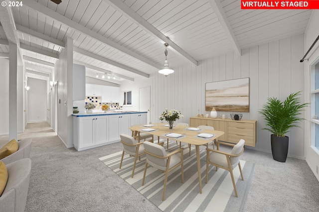 dining room featuring baseboards, vaulted ceiling with beams, and light carpet