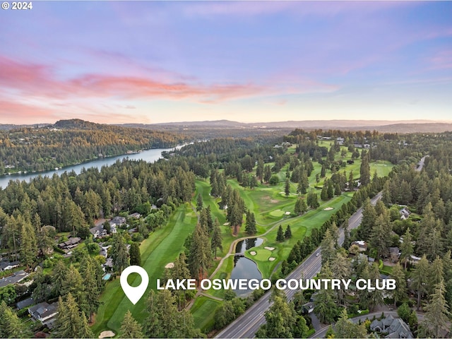 birds eye view of property with golf course view, a water view, and a wooded view