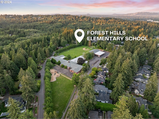 aerial view at dusk with a forest view and a residential view
