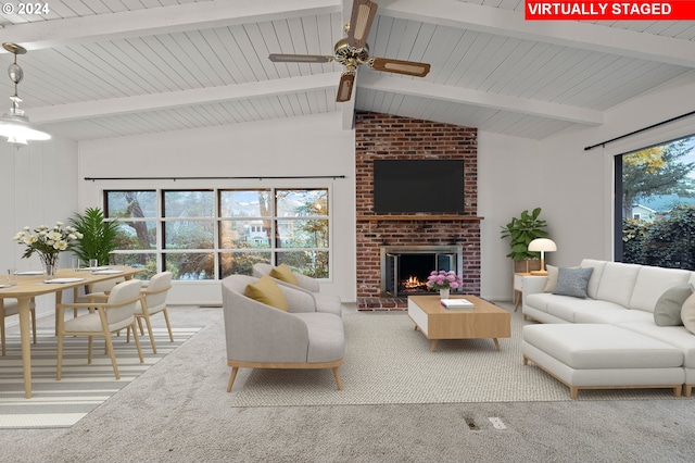carpeted living area featuring lofted ceiling with beams, a fireplace, and a ceiling fan