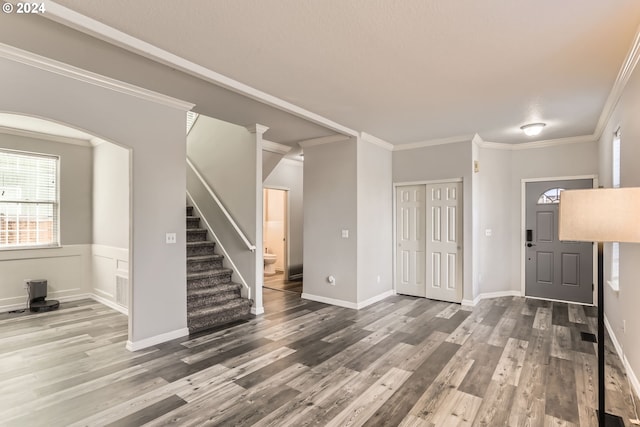 foyer featuring wood-type flooring and crown molding