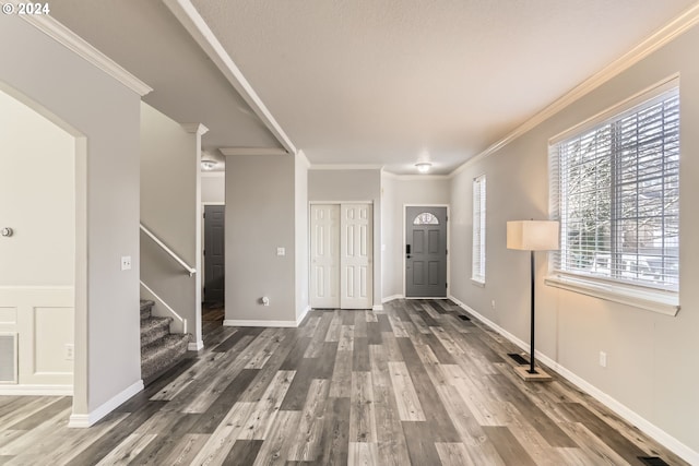 entryway with dark hardwood / wood-style flooring and crown molding