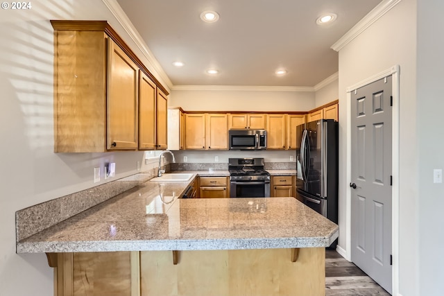 kitchen featuring a breakfast bar, sink, crown molding, kitchen peninsula, and stainless steel appliances