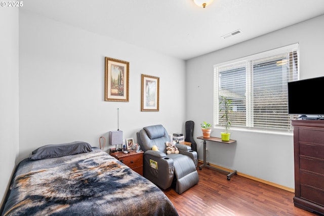 bedroom featuring wood finished floors, visible vents, and baseboards