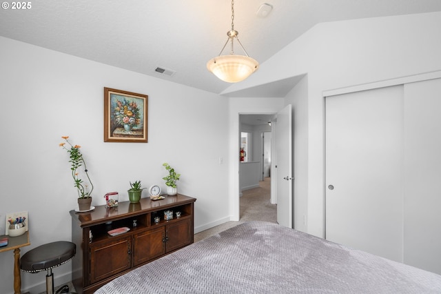 interior space with lofted ceiling, carpet flooring, visible vents, and baseboards