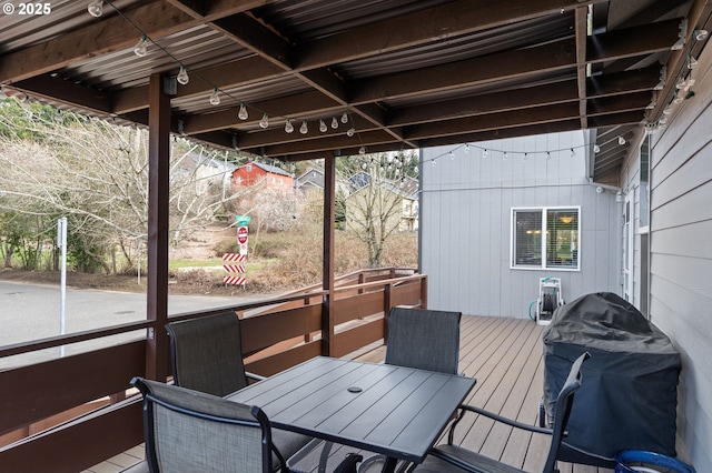 wooden terrace featuring outdoor dining space and area for grilling