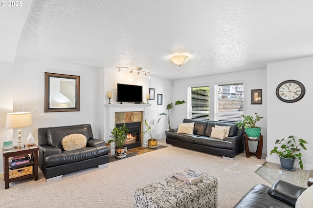 carpeted living room featuring rail lighting, a fireplace, baseboards, and a textured ceiling