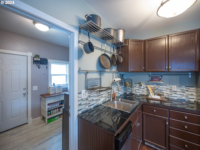 kitchen with stainless steel dishwasher, sink, light wood-type flooring, and decorative backsplash