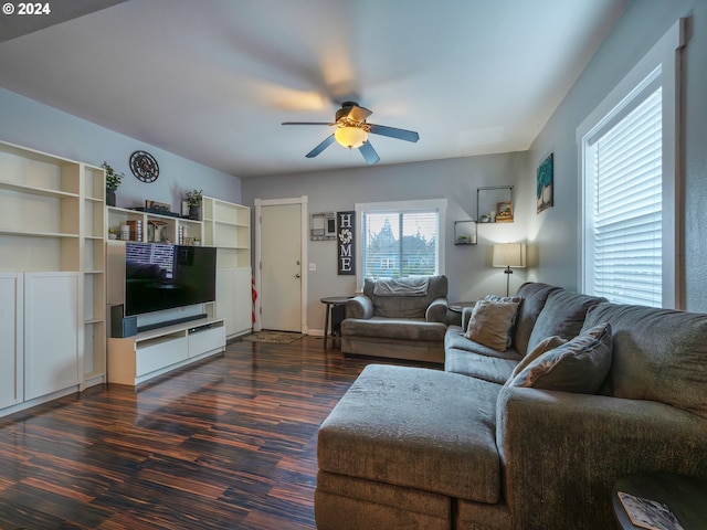 living room featuring dark wood-type flooring and ceiling fan