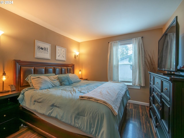 bedroom with dark hardwood / wood-style flooring