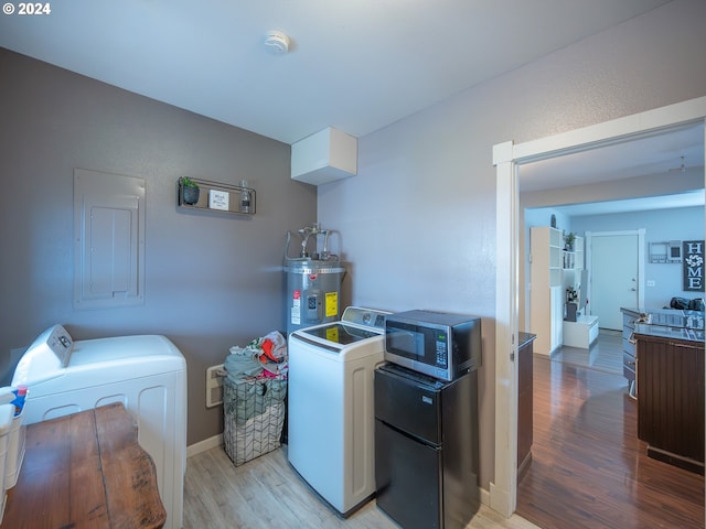 laundry room with washing machine and dryer, secured water heater, electric panel, and light wood-type flooring