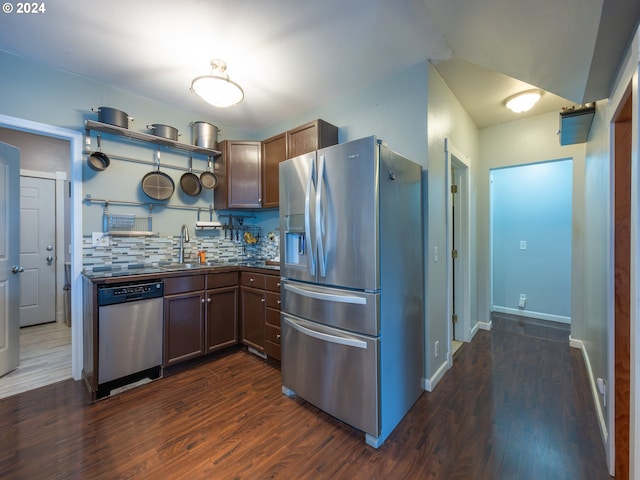 kitchen with appliances with stainless steel finishes, dark hardwood / wood-style floors, sink, and backsplash