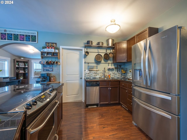 kitchen featuring dark hardwood / wood-style flooring, backsplash, sink, and stainless steel appliances