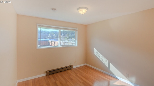 spare room with light hardwood / wood-style floors and a baseboard heating unit