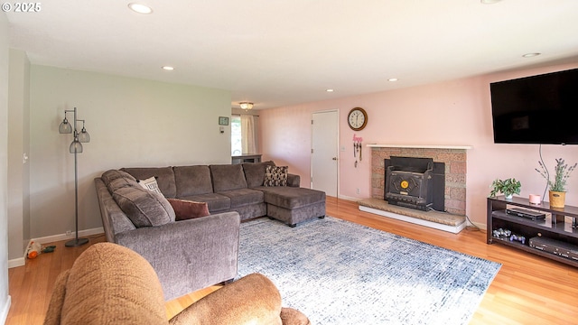 living room featuring wood-type flooring and a wood stove