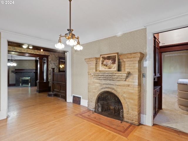 unfurnished living room with ornamental molding, a brick fireplace, and hardwood / wood-style flooring