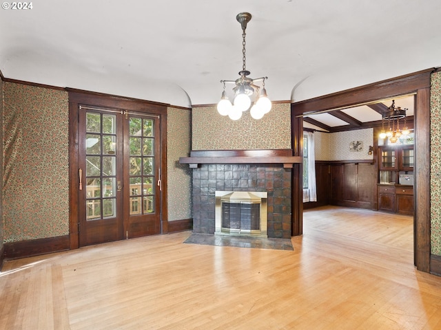 unfurnished living room featuring light wood-type flooring and a chandelier