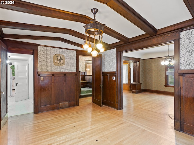 dining room with lofted ceiling with beams, light hardwood / wood-style floors, and an inviting chandelier