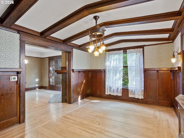 unfurnished dining area with a notable chandelier, lofted ceiling with beams, and light hardwood / wood-style floors