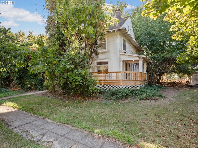 view of side of property with a wooden deck and a lawn