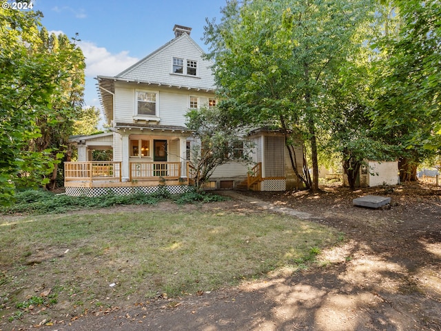 view of front of house with a front yard and a wooden deck