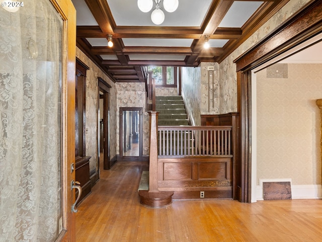 interior space with beamed ceiling, coffered ceiling, and hardwood / wood-style floors