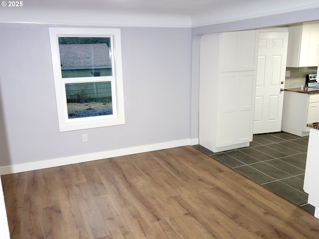 tiled spare room featuring crown molding