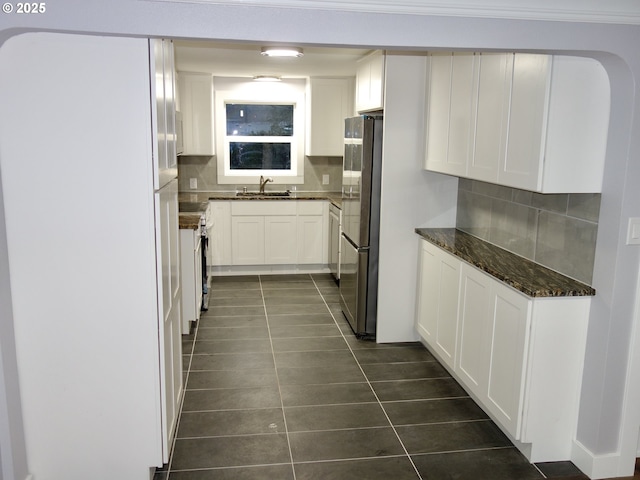 kitchen with decorative backsplash, white cabinetry, stainless steel fridge, and white fridge