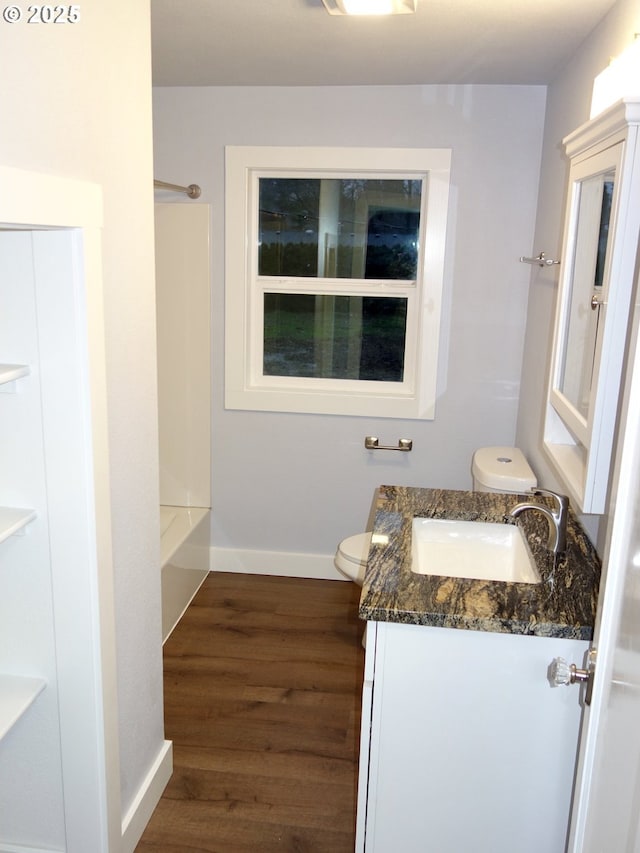 full bathroom with toilet, bathing tub / shower combination, hardwood / wood-style flooring, and vanity