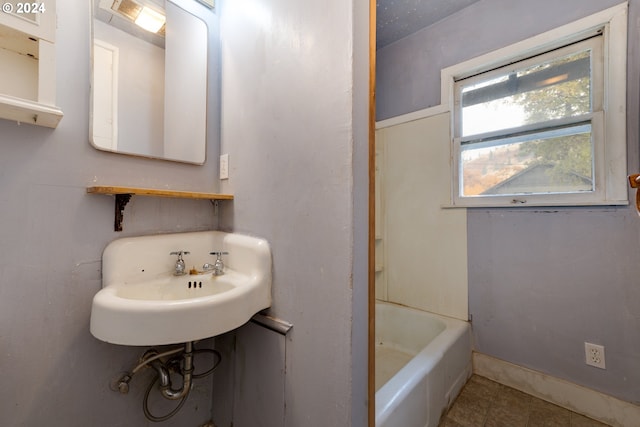 bathroom featuring sink and a tub to relax in